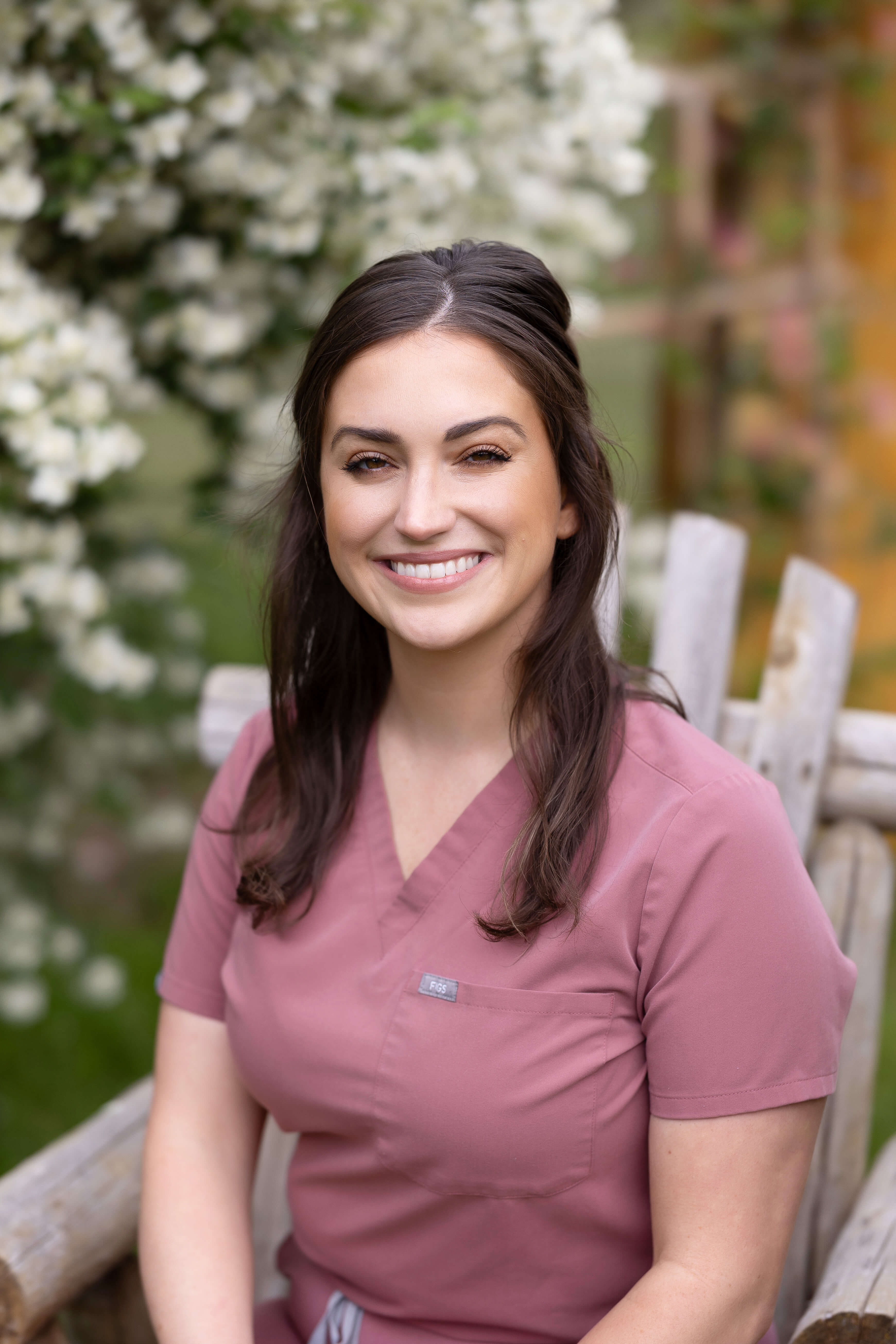 Female veterinarian in pink scrubs sitting outside in chair