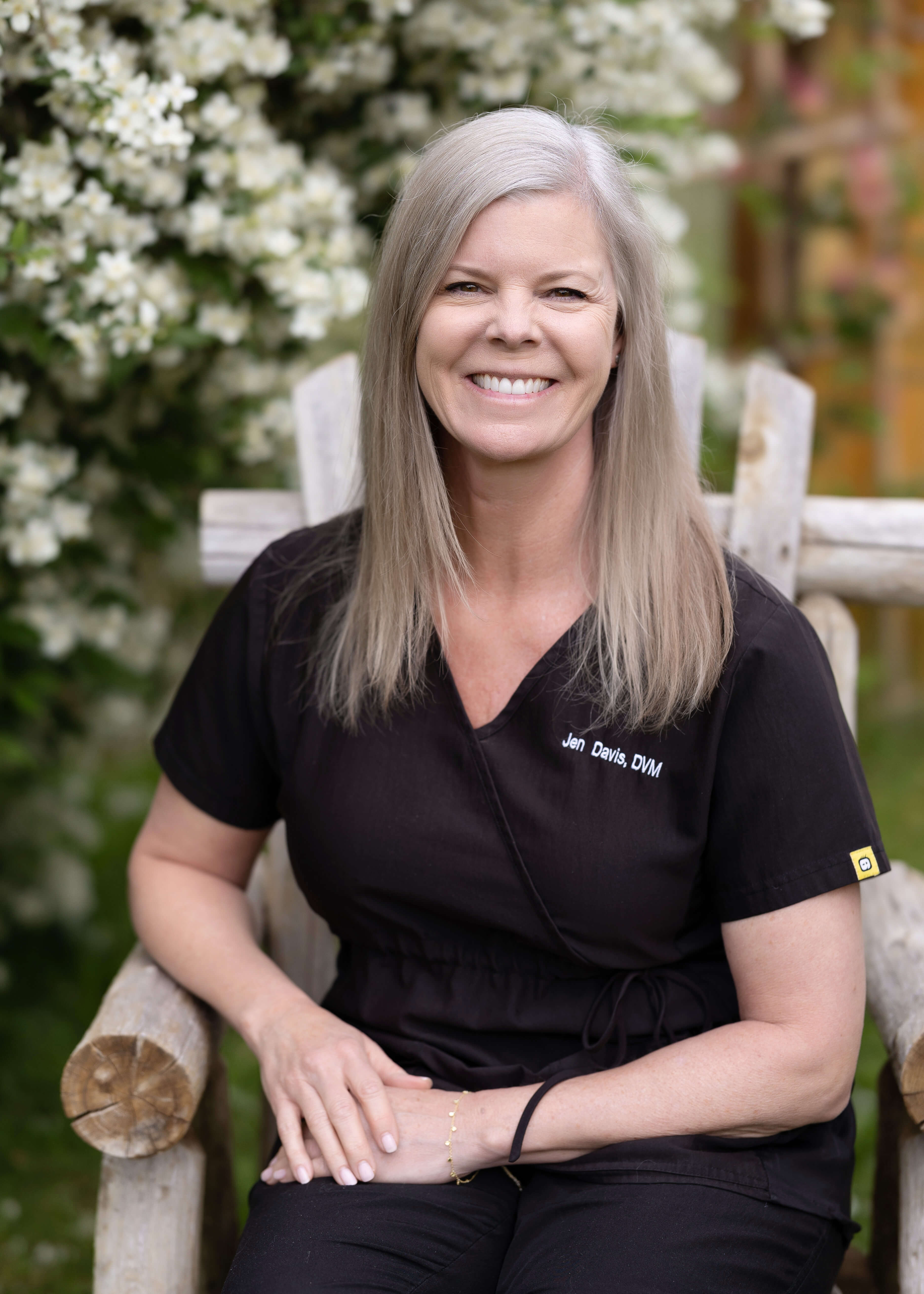 Woman veterinarian sitting outside in a chair.