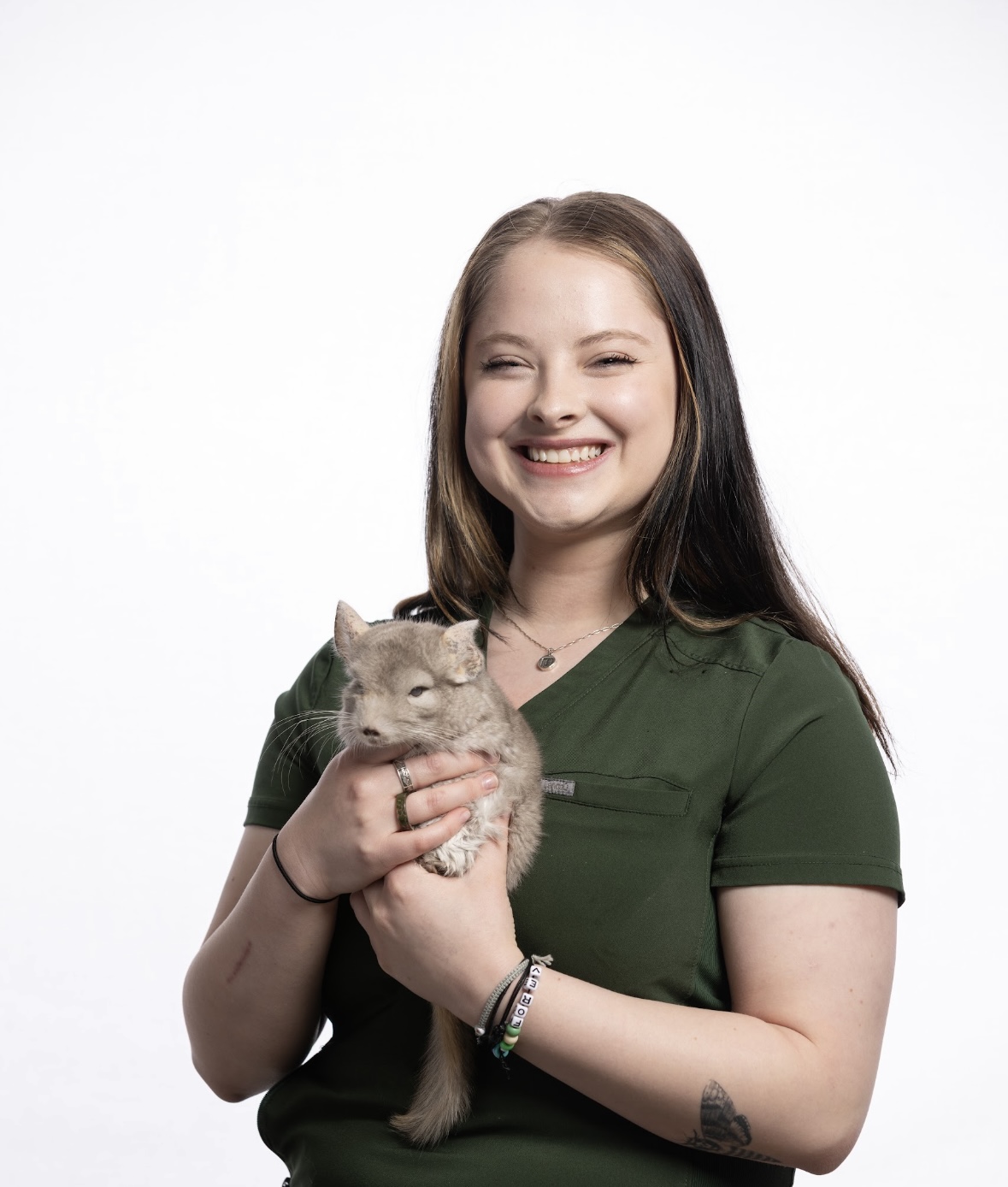 Woman in green scrubs holding a chinchilla