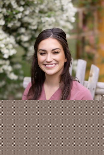 Female veterinarian in pink scrubs sitting outside in chair